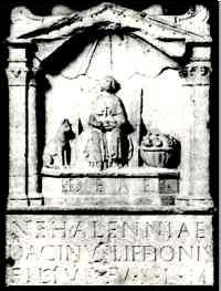 Votiefbeeld voor Nehallenia. Links zit haar hond, rechts staat een mand met appelen. Het altaar wordt overkoepeld door een schelp.