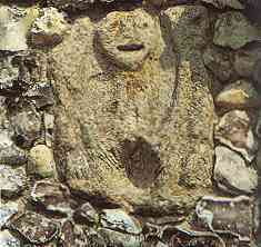 Sheela ingemetseld hoog boven de ingang van de kerk van Buckland, buckinghamshire, Engeland. De steen waarin de Sheela is gekerfd is anders dan die van de rest van de gevel.